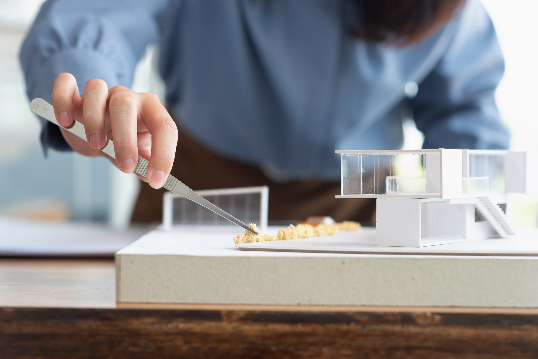 Architect beside a model of a house with a glass façade