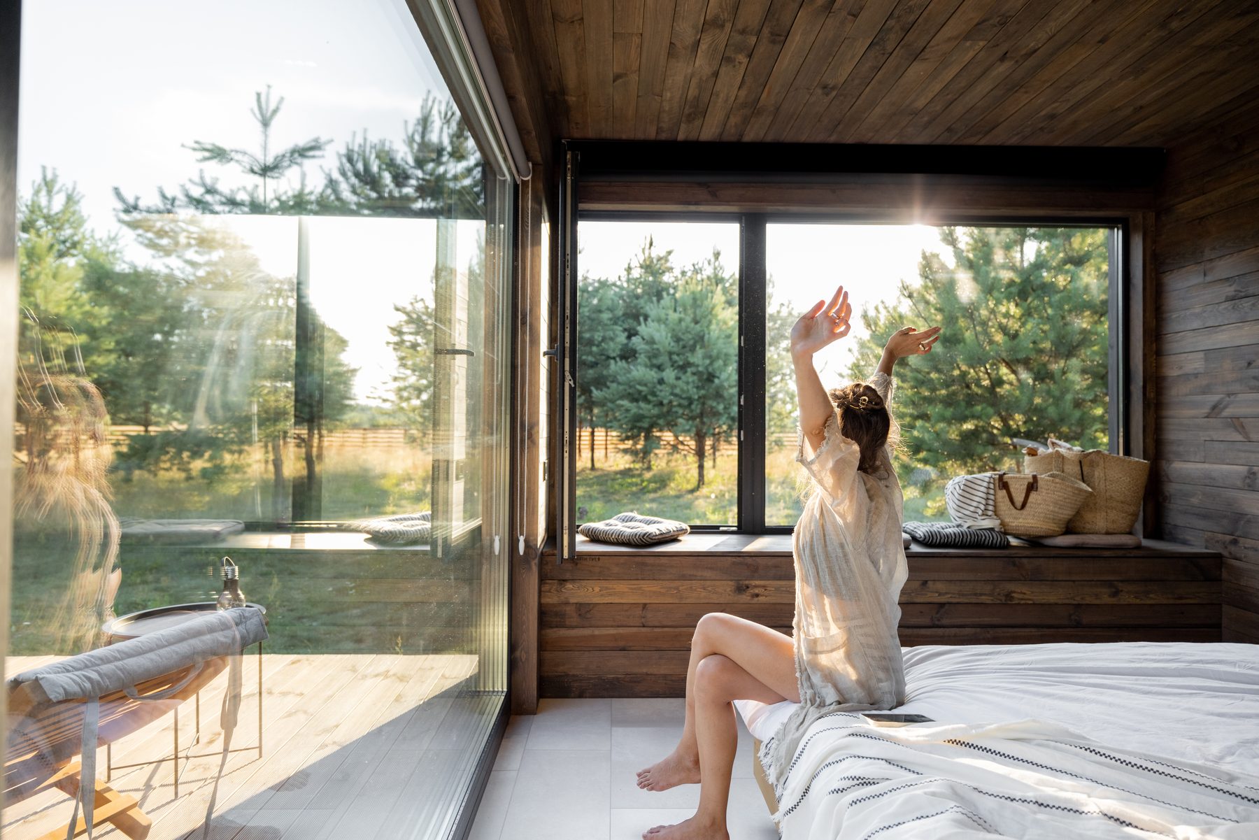 Schlafzimmer mit großen Glaswänden und Morgensonne
