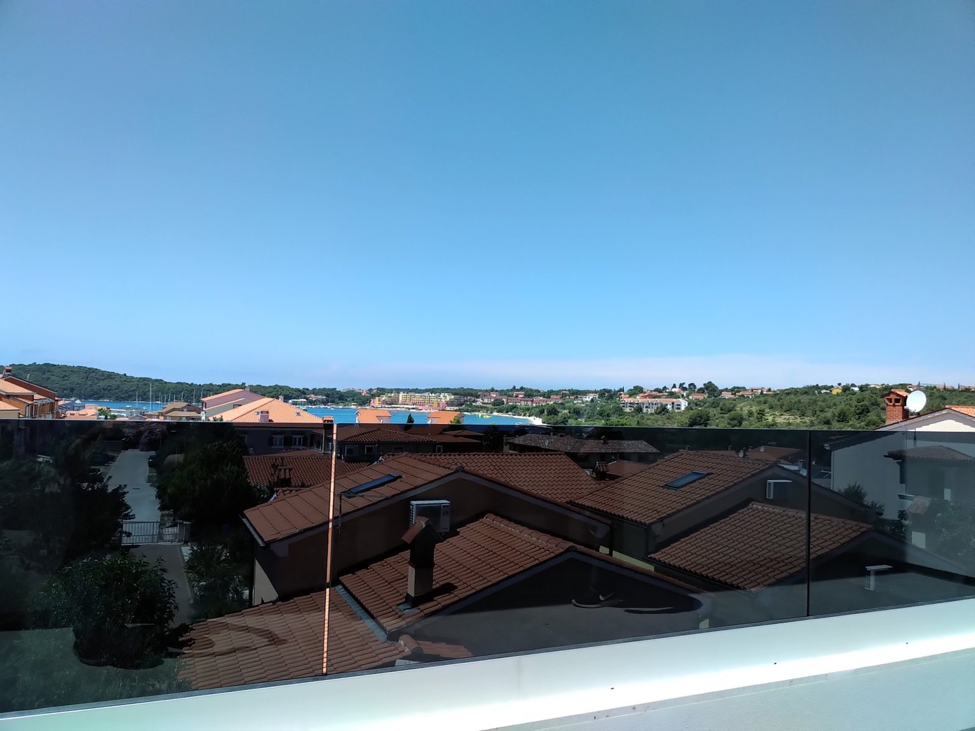 Glasgeländer aus dunkelgrauem Parsol auf einer Terrasse mit Meerblick